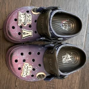 Kids size 13 looney tunes crocs with charms displayed